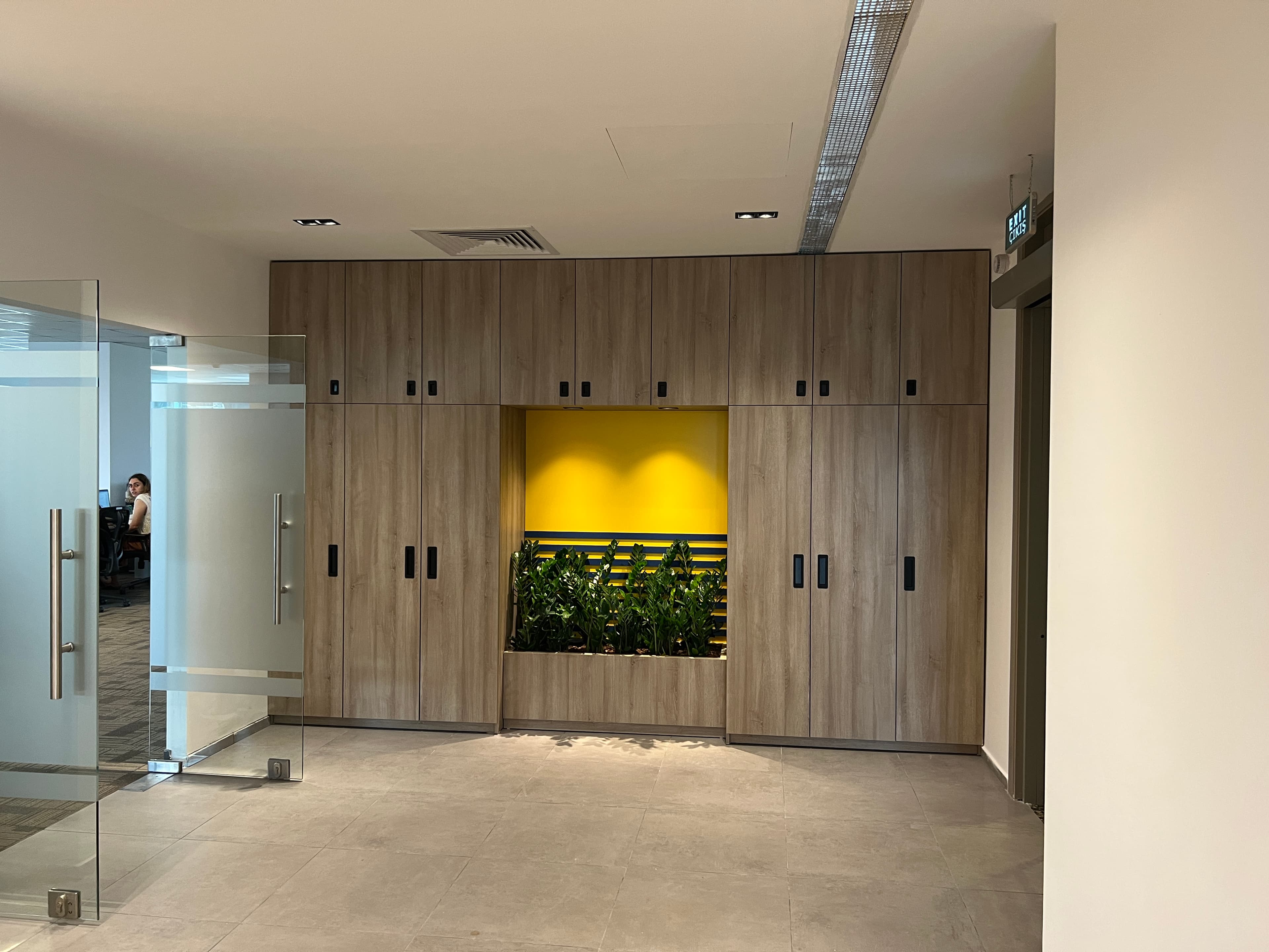 Marka sarısıyla çerçevelenmiş gömme saksı nişi, dolaşım alanına doğayı taşıyor.