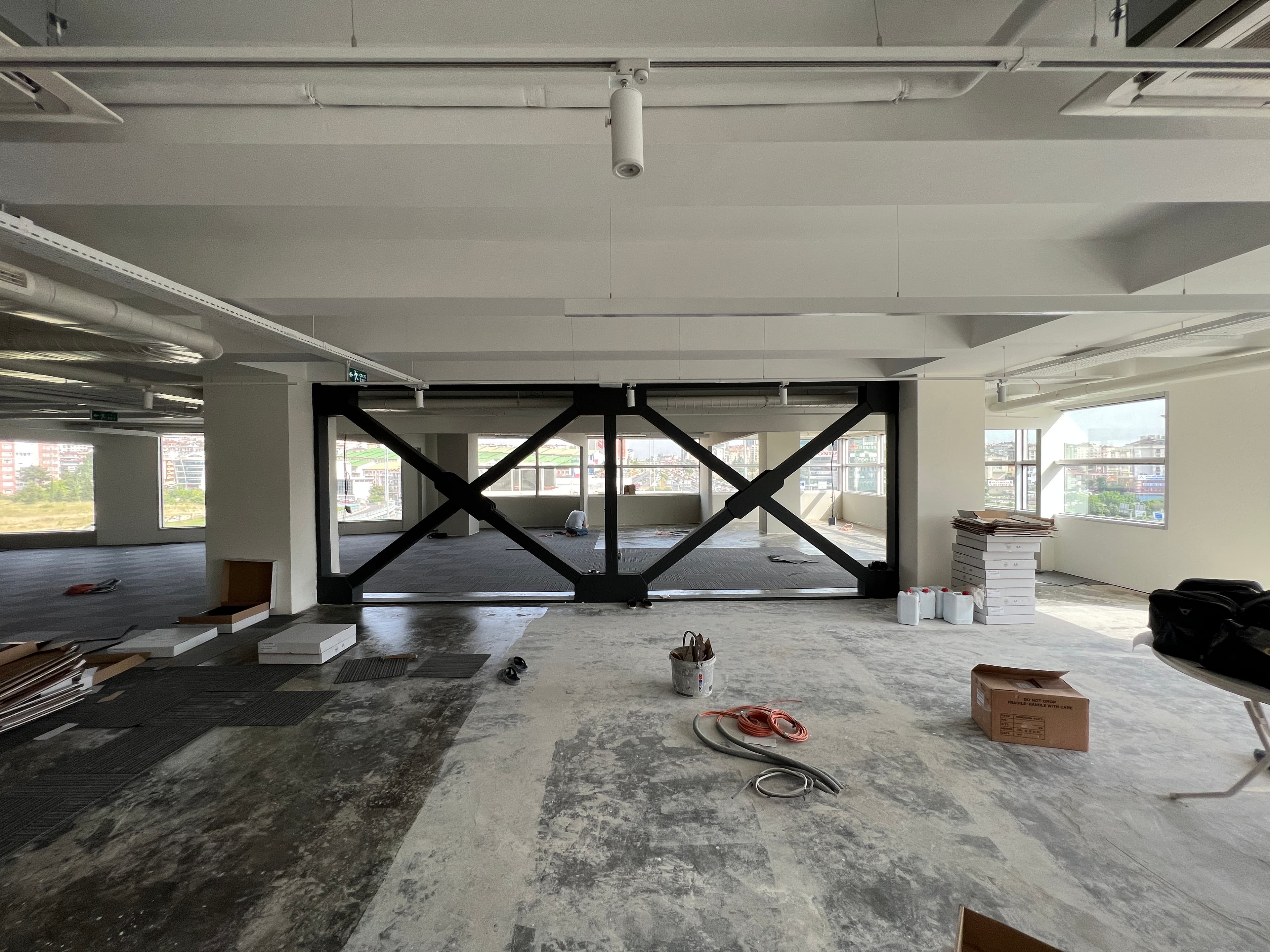 Construction view with steel X-bracing and scattered materials on floor