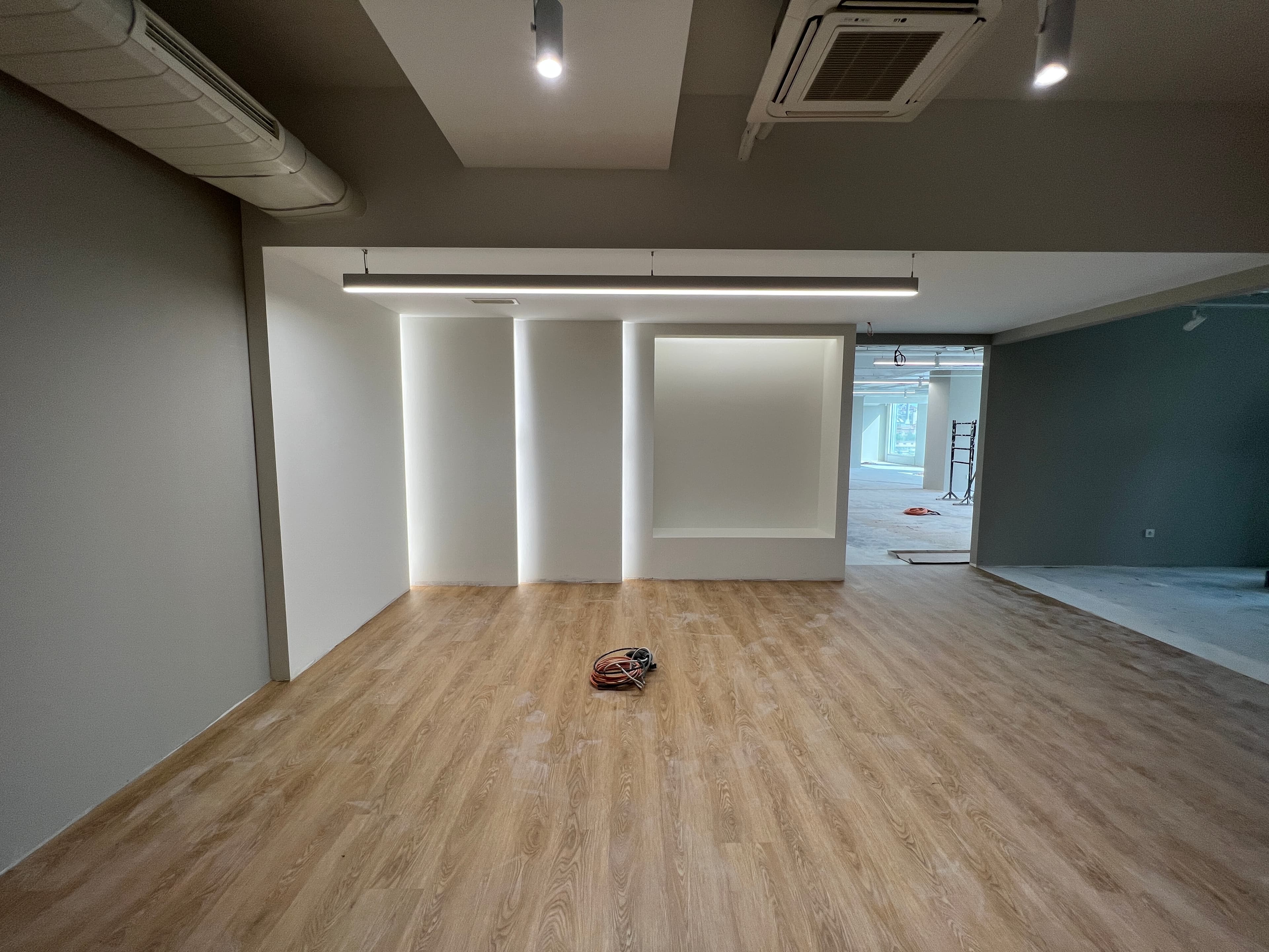 Reception nearing completion with illuminated wall niches and oak flooring