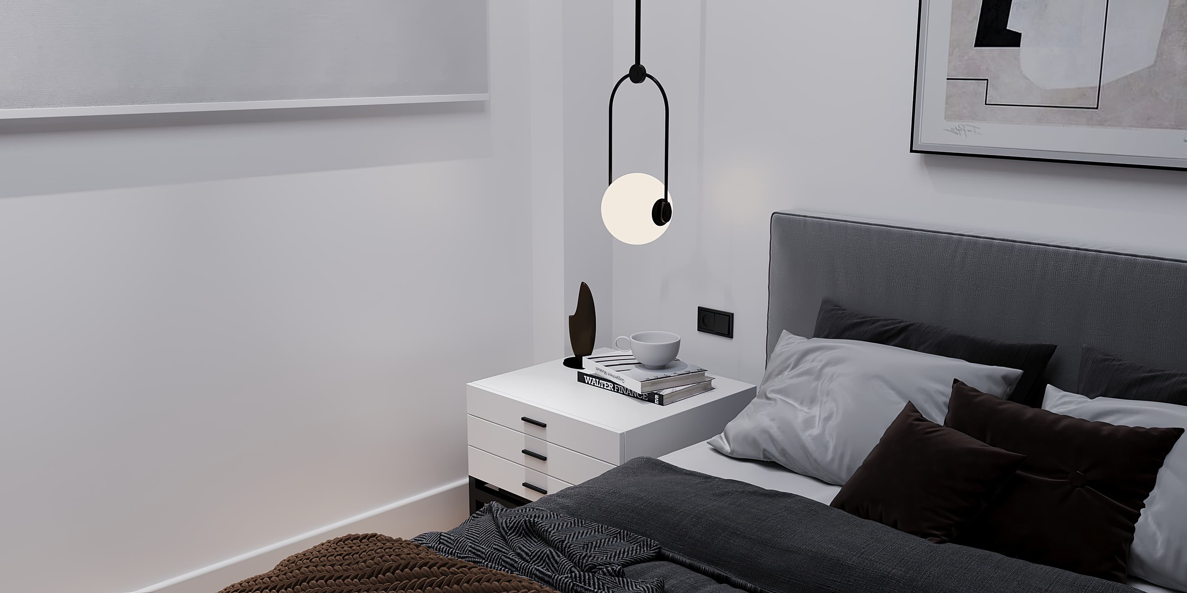 Bedside detail with globe pendant, white nightstand, and stacked books
