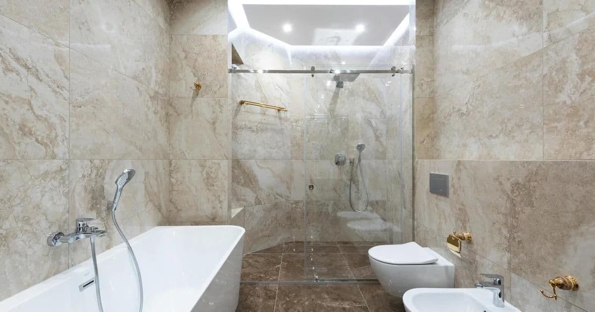 Luxury bathroom with freestanding stone tub, natural stone walls, and warm ambient lighting